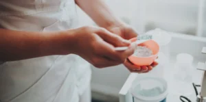 close up of someone using a spoon to mix powder in a bowl